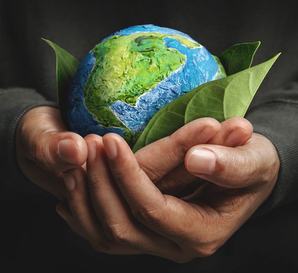 World Earth Day Concept. Green Energy, ESG, Environmental, social and corporate governance. Renewable and Sustainable Resources. Environmental and Ecology Care. Hand Embracing Green Leaf and Globe